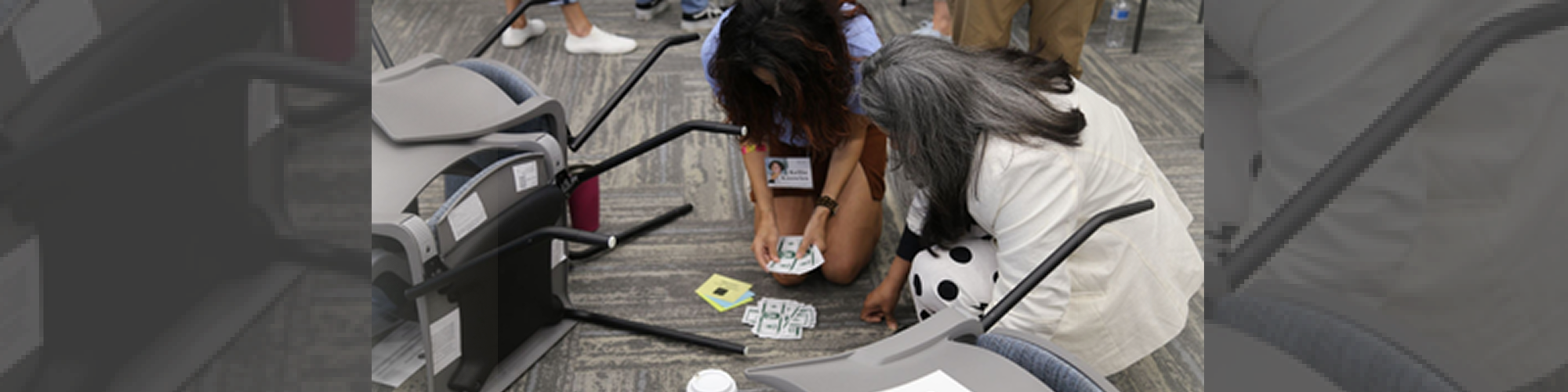 Two people counting cash beside overturned chairs