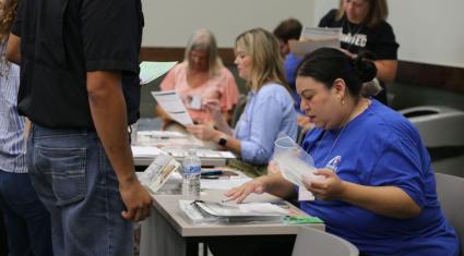Volunteer assisting participants with registration at a community event