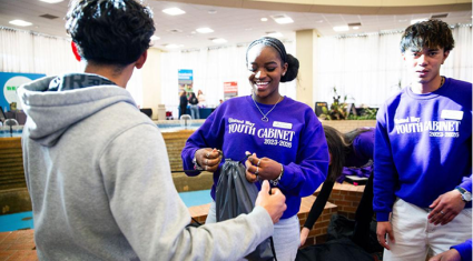 Youth volunteers handing out materials during a leadership event in Amarillo